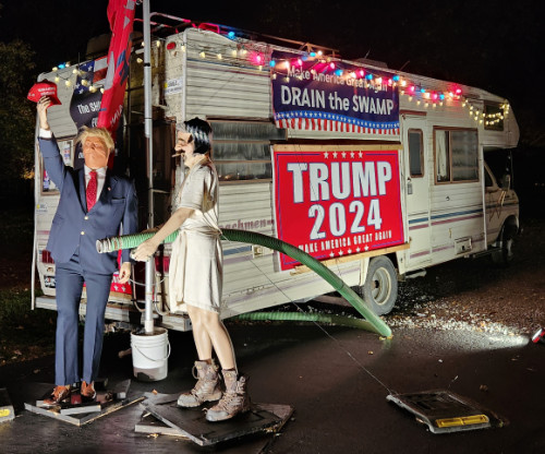 It recreates the 
scene from the movie where Cousin Eddie is emptying his RV's septic tank; this year it has Donald Trump standing
there as well, along with 'drain the swamp' signs on the RV