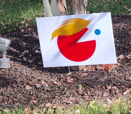 A red-colored Pac-Man with
Trump hair tries to eat a blue dot