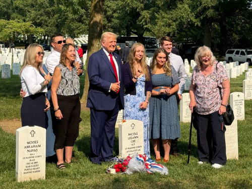 Trump, and about eight other people,
presumably family members, stand around the grave of Nicole Gee, while Trump smiles and gives a thumbs up