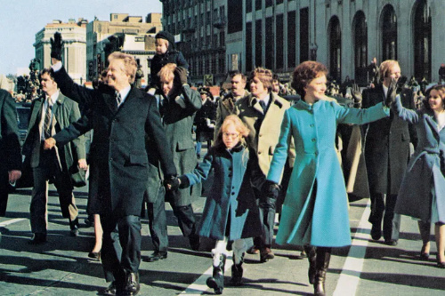 Jimmy and Rosalynn Carter, with
Amy Carter between them, walk during their inaugural