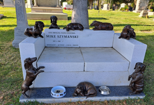A tombstone shaped like a full-sized
couch, with eight different dachshund sculptures placed upon it