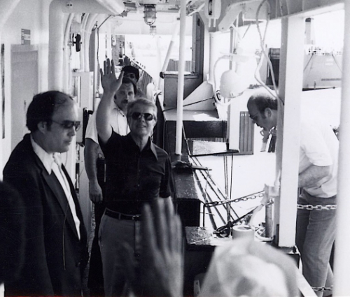 Jimmy Carter, in casual
clothes and aviator sunglasses, waves at the photographer on board the ship